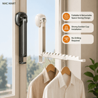 A wall-mounted retractable clothesline with suction cups shown attached to a window. The white lineal unit hangs from the window frame, with two wooden hangers holding light-colored shirts below.