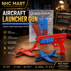 A red and blue plastic foam aircraft launcher gun set with red and blue foam airplanes on a wooden table, with a clear plastic bag of more foam airplanes in the background. The image features multiple text overlays highlighting product features and brand 'NHC MART'.