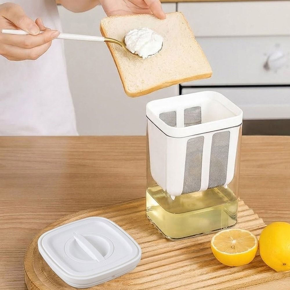 Person spreading cream on toast with a kitchen appliance on a wooden surface