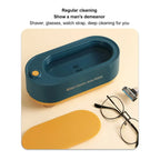 Mini cleaning machine with shaver, glasses, and watch strap on a beige background