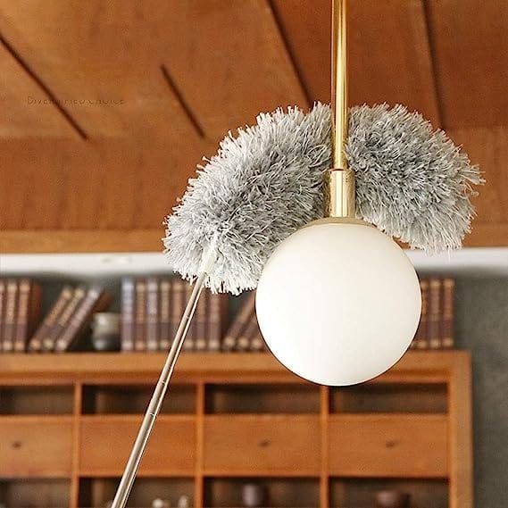 Decorative ceiling light fixture with fluffy gray ends in a room setting.