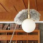 Decorative ceiling light fixture with fluffy gray ends in a room setting.